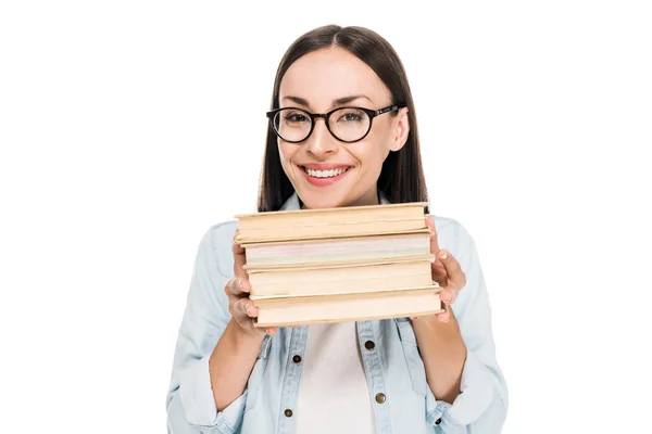 Chica morena feliz en gafas en chaqueta de mezclilla sosteniendo libros aislados en blanco - foto de stock