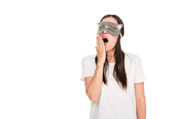 Brunette young woman in cat sleeping eye mask yawning isolated on white — Stock Photo