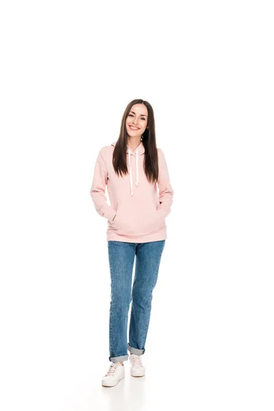 Full length view of smiling girl in casual outfit standing with hands in pockets isolated on white — Stock Photo