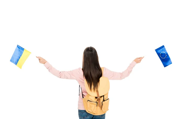 Back view of student with backpack holding Ukrainian and European flags in hands isolated on white — Stock Photo