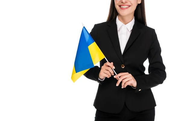 Recortado vista de sonriente mujer de negocios en traje negro sosteniendo bandera ucraniana aislado en blanco - foto de stock