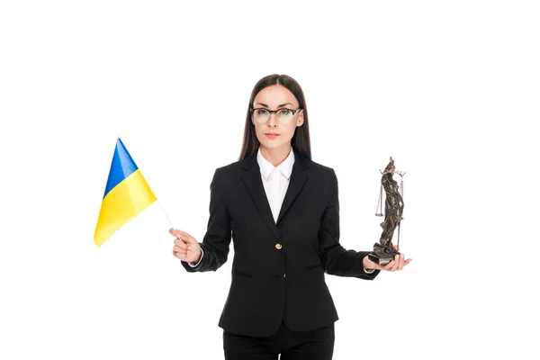 Abogado en traje con bandera de Ucrania y bronce Estatuilla Themis aislado en blanco - foto de stock