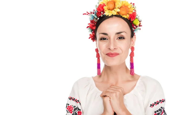 Feliz morena joven en camisa bordada ucraniana nacional y corona floral aislada en blanco - foto de stock