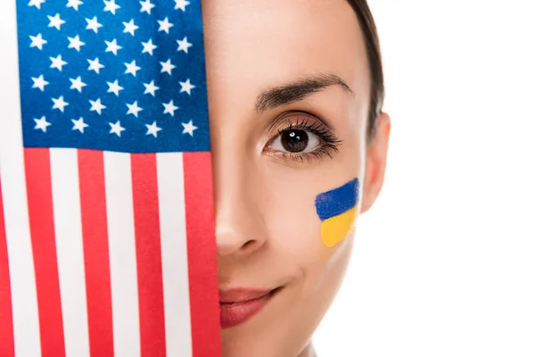 Jeune femme souriante avec drapeau ukrainien peint sur le visage tenant drapeau américain isolé sur blanc — Photo de stock