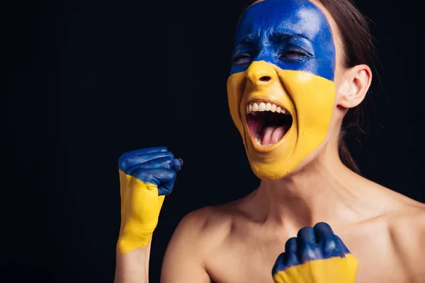 Jovem mulher nua com bandeira ucraniana pintada na pele gritando isolado no preto — Fotografia de Stock