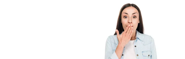 Возбужденная брюнетка женщина покрывая рот рукой изолированы на белом, панорамный снимок — стоковое фото