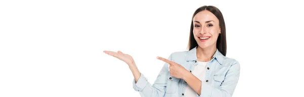 Souriant heureux brunette femme pointant avec doigt de côté isolé sur blanc, panoramique shot — Photo de stock