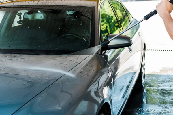 Ausgeschnittene Ansicht eines Mannes, der sein graues Auto draußen wäscht — Stockfoto