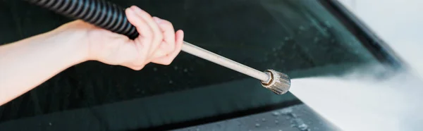 Panoramic shot of man washing modern automobile outside — Stock Photo