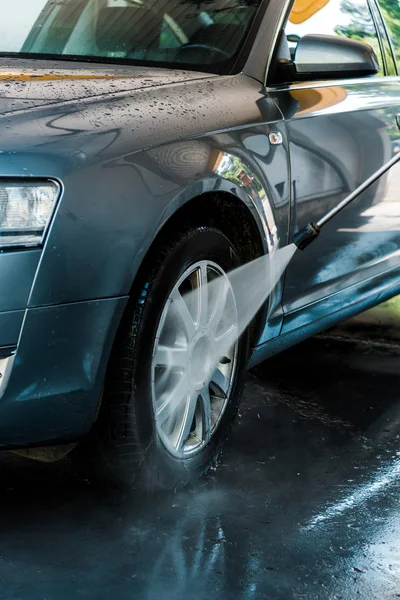 Messa a fuoco selettiva della pressione dell'acqua sulla ruota dell'auto — Foto stock