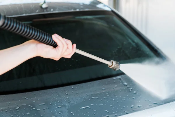 Ausgeschnittene Ansicht von Autoreiniger, der Auto mit Wasserdruck wäscht — Stockfoto