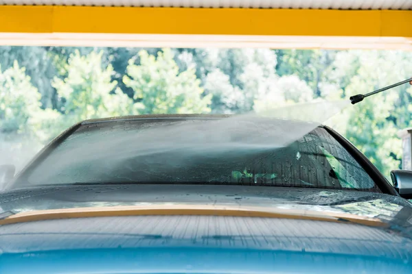 Pressão da água no automóvel moderno cinzento fora na lavagem do carro — Fotografia de Stock