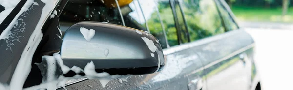 Tiro panorâmico do espelho do carro com espuma branca na lavagem do carro — Fotografia de Stock