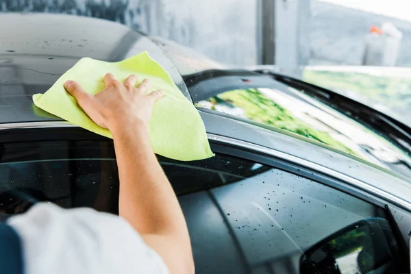 Messa a fuoco selettiva di lavaggio auto tenendo straccio verde e pulizia auto — Foto stock