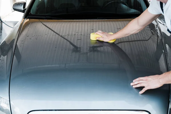 Abgeschnittene Ansicht eines Mannes mit gelbem Schwamm beim Reinigen von Auto — Stockfoto