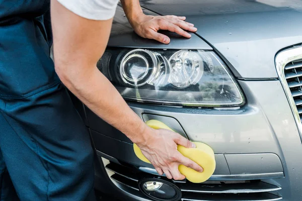Cropped view of man holding sponge while cleaning car — Stock Photo