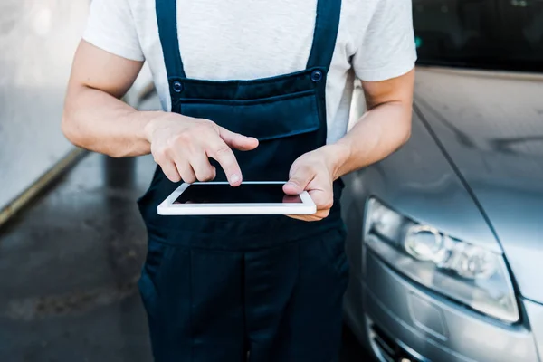 Foyer sélectif de l'homme pointant avec le doigt à la tablette numérique près de la voiture — Photo de stock