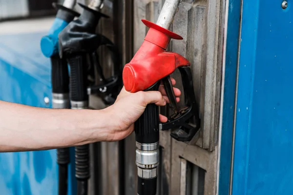 Foco seletivo do homem que detém bomba de gás vermelha no posto de gasolina — Fotografia de Stock