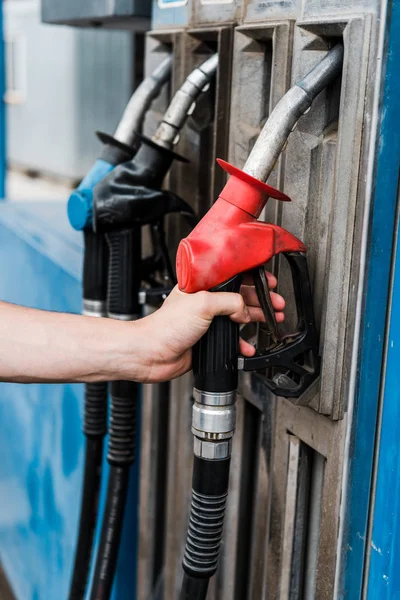 Vue recadrée de l'homme tenant la pompe à essence rouge sur la station-service — Photo de stock