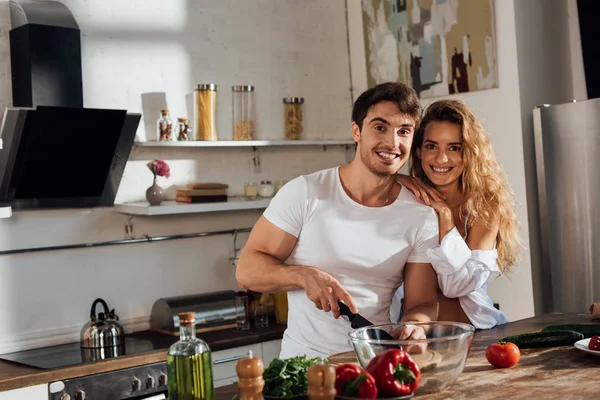 Sexy pareja sonriendo mientras cocinar juntos en cocina — Stock Photo