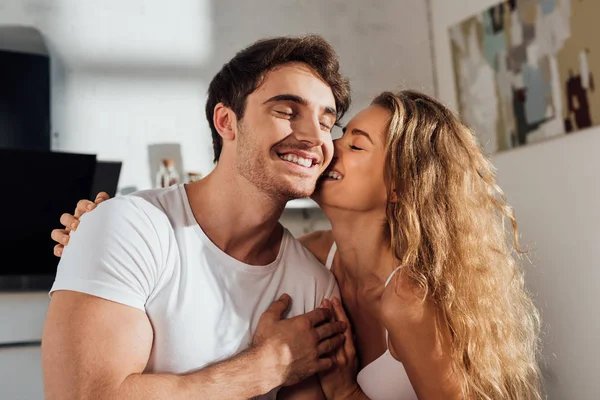 Feliz casal sexy abraçando e sorrindo em casa — Fotografia de Stock