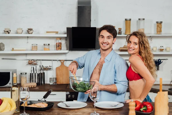 Couple sexy cuisine ensemble et souriant dans la cuisine — Photo de stock