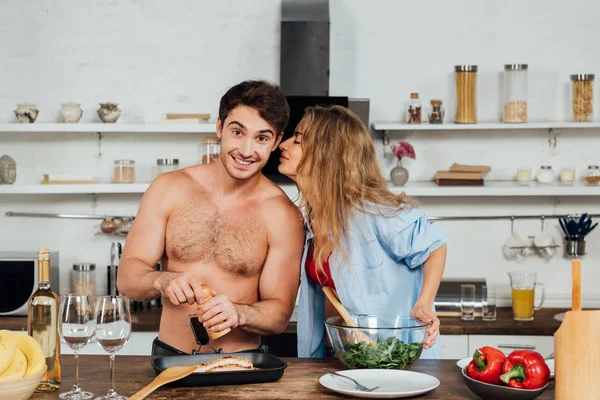 Menina sexy beijando namorado enquanto cozinha na cozinha — Fotografia de Stock