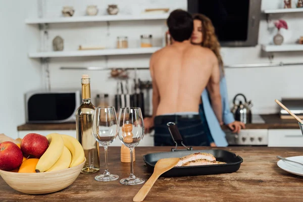 Selective focus of kissing couple and served table on foreground — Stock Photo