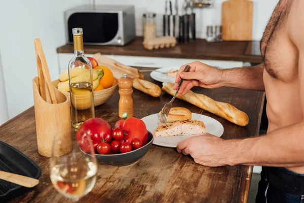 Vista recortada del hombre sin camisa desayunando en la cocina - foto de stock