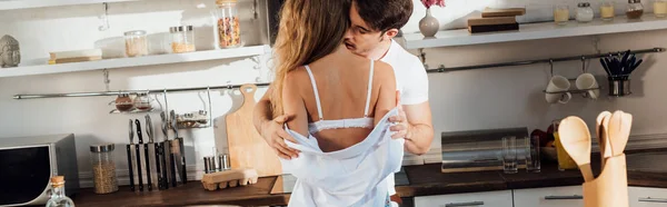 Plano panorámico del hombre desnudando novia sexy en la cocina - foto de stock