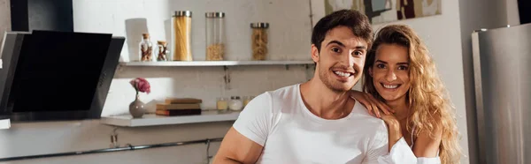 Plano panorámico de feliz pareja sonriente en la cocina - foto de stock