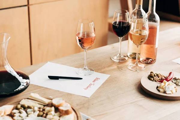 Weindegustationsdokument, Weingläser, Flaschen und Essen auf Holztisch — Stockfoto