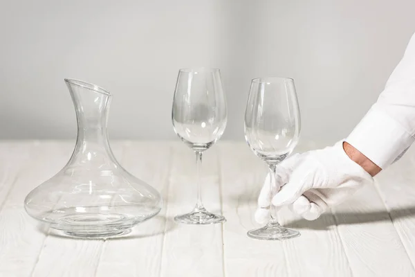 Vista parziale del cameriere che tiene il bicchiere di vino vuoto nel ristorante — Foto stock