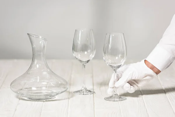 Partial view of waiter holding empty wine glass in restaurant — Stock Photo