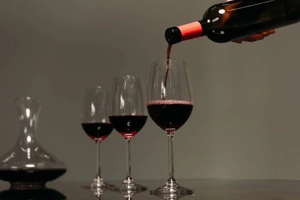 Visão parcial do homem derramando vinho em copos de vinho no restaurante — Fotografia de Stock