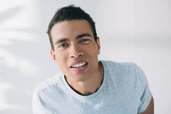 Concentrated handsome man blinking while looking at camera — Stock Photo