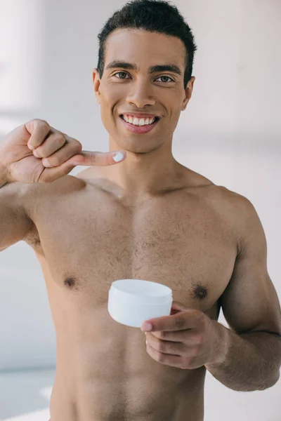 Bonito misto raça homem colocando alguns creme no dedo e apresentá-lo para câmera — Fotografia de Stock