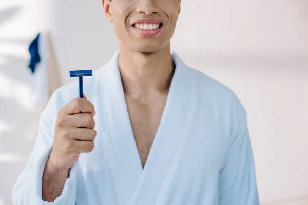 Cropped view of man in bathrobe holding razor for shaving — Stock Photo