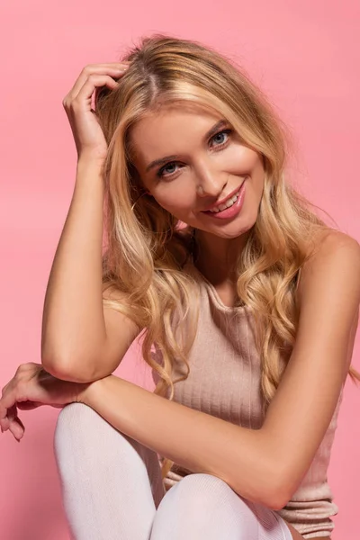 Улыбающаяся красивая блондинка, изолированная на розовый — стоковое фото