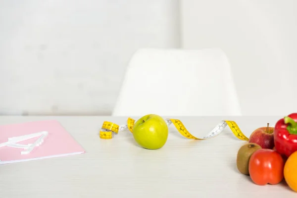 Folder, measure tape and fresh fruits and vegetables on table — Stock Photo