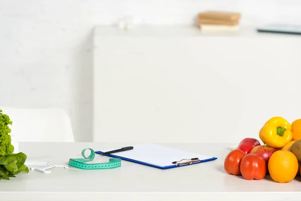 Klemmbrett mit Stift, Maßband und frischem Obst und Gemüse auf dem Tisch — Stockfoto
