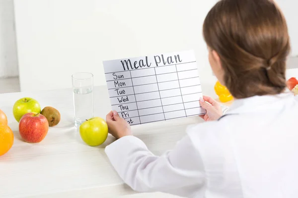 Back view of dietitian holding meal plan at workplace — Stock Photo