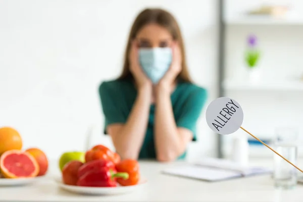 Selective focus of woman in medical mask propping face with hands and nameplate with inscription allergy — Stock Photo