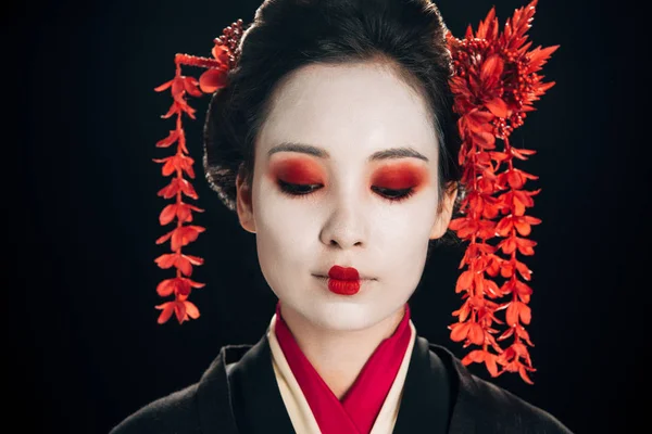 Retrato de hermosa geisha con flores en el pelo aislado en negro - foto de stock