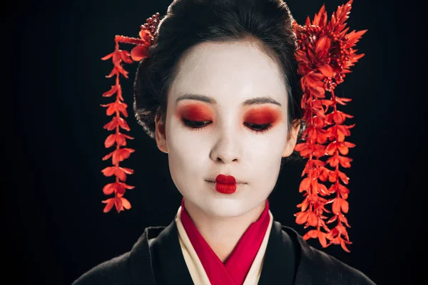 Portrait of beautiful geisha with flowers in hair isolated on black — Stock Photo