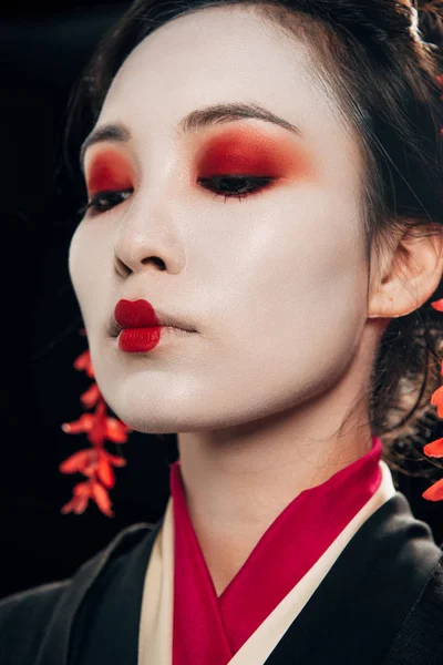 Niedrigwinkel-Ansicht der schönen Geisha mit rotem Lidschatten und Lippen isoliert auf schwarz — Stockfoto