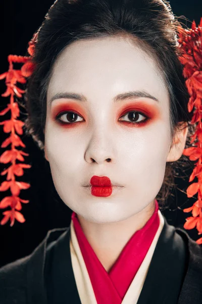 Portrait of beautiful geisha with red eyeshadow and lips isolated on black — Stock Photo