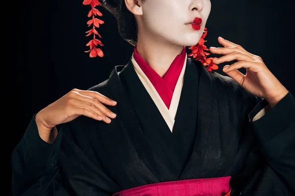 Visão parcial da bela gueixa em preto e vermelho kimono gesto isolado em preto — Fotografia de Stock