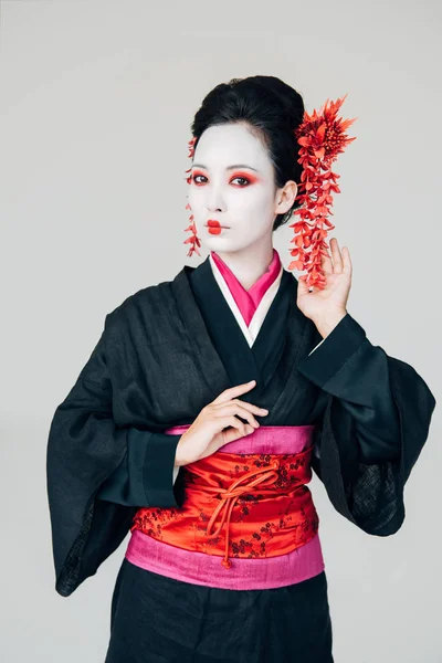 Schöne Geisha in schwarzem und rotem Kimono isoliert auf weiß — Stockfoto