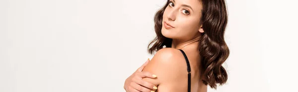 Panoramic shot of attractive woman in black bra looking at camera on white — Stock Photo